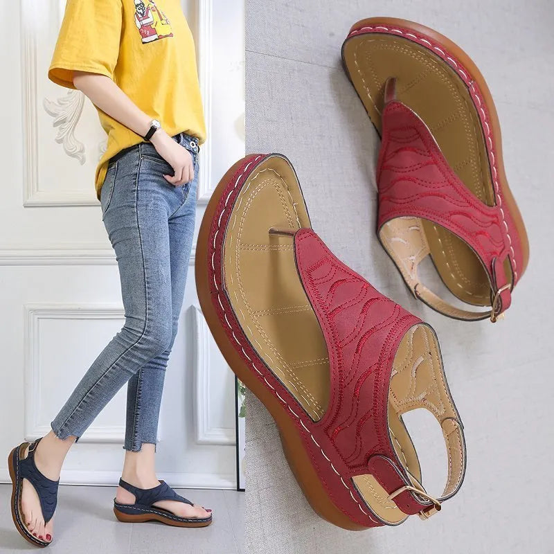 Women's black wedge heel sandals with an adjustable buckle strap on a light background.