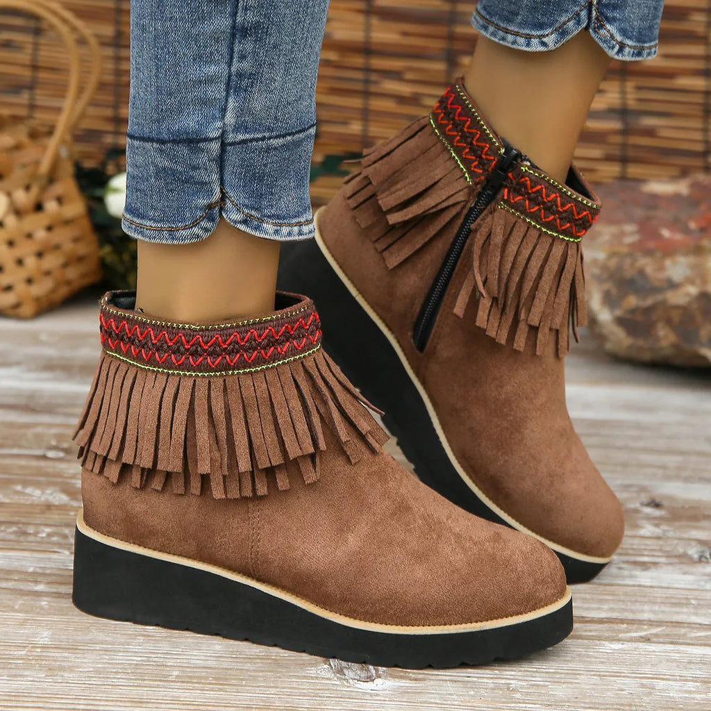Women's dark brown suede ankle booties with a wedge heel, side zipper, and tassel detail