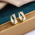 Geometric copper earrings with 14K yellow finish and zircon treatment.