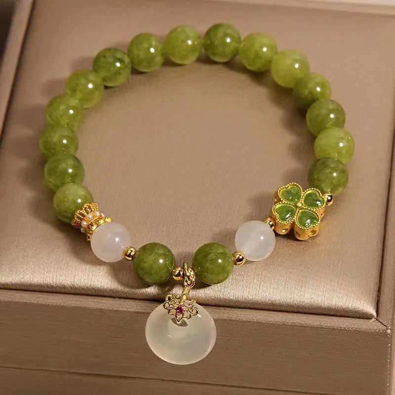 Natural stone green tourmaline women's bracelet with peace buckle and lucky bag charm on display