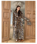 Women's faux fur coat with fox fur collar in street fashion style showing pockets and regular sleeves