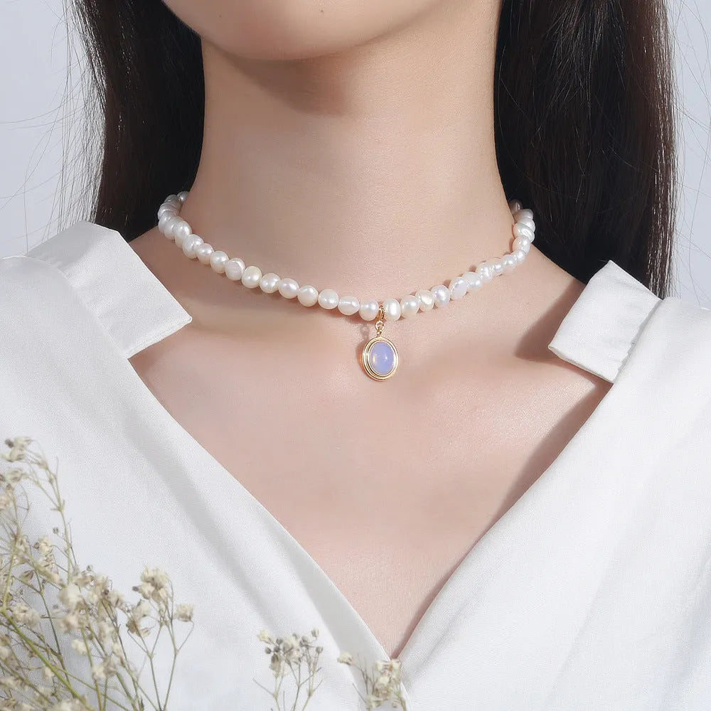 Close-up of a round 925 sterling silver necklace with an irregular geometric pearl pendant on a white background.