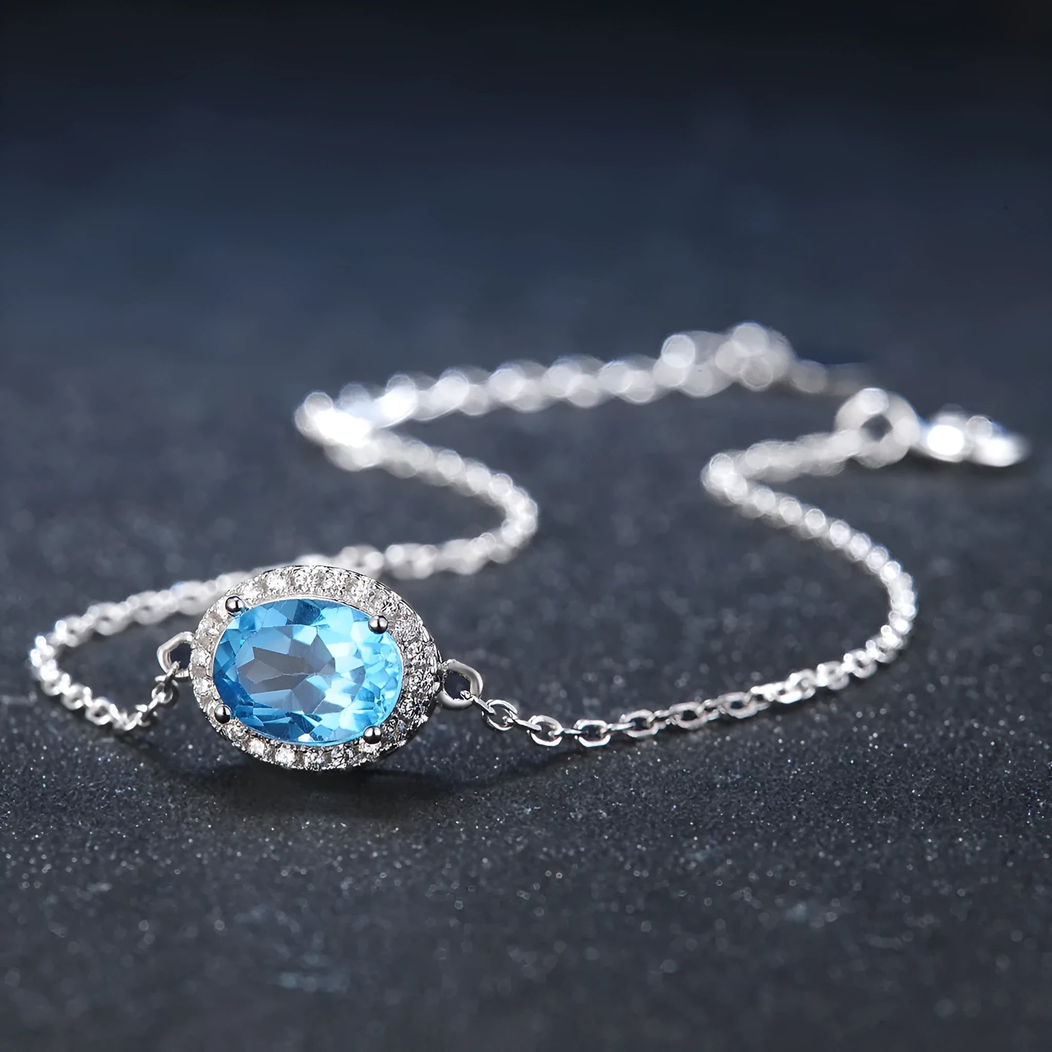 Women's sterling silver jewellery set with blue topaz gems featuring geometric earrings, ring, necklace and pendant
