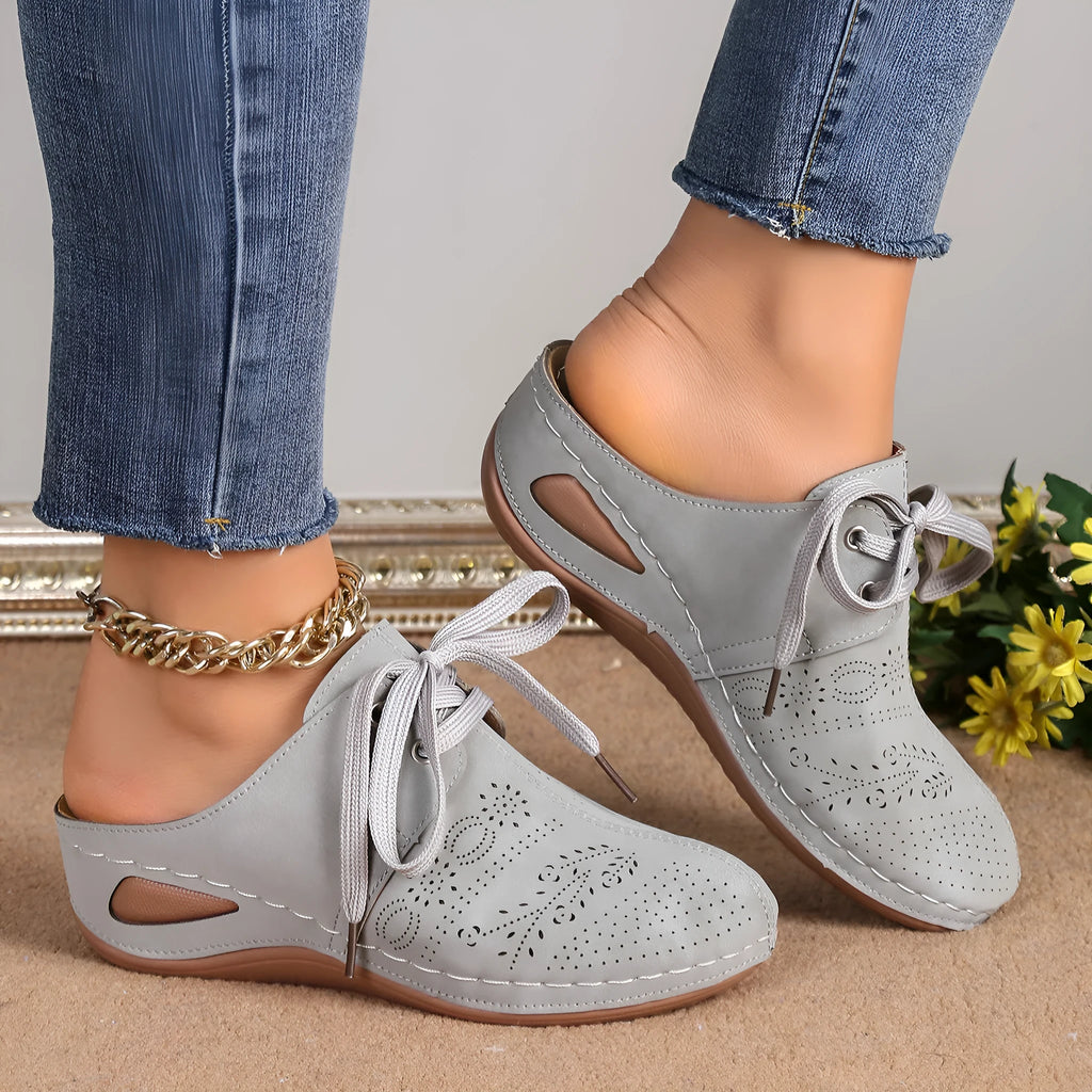 Women's black suede lace-up wedge slippers with a hollow out design and rubber sole.