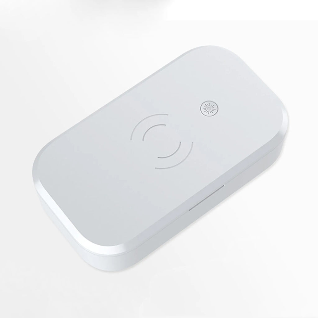 White ultraviolet disinfection box with wireless phone charger on top, shown with nail tools inside.