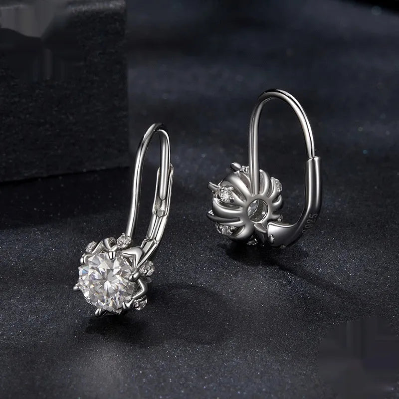 Close-up of a sterling silver floral bud ear clip with a moissanite stone and white gold plating.