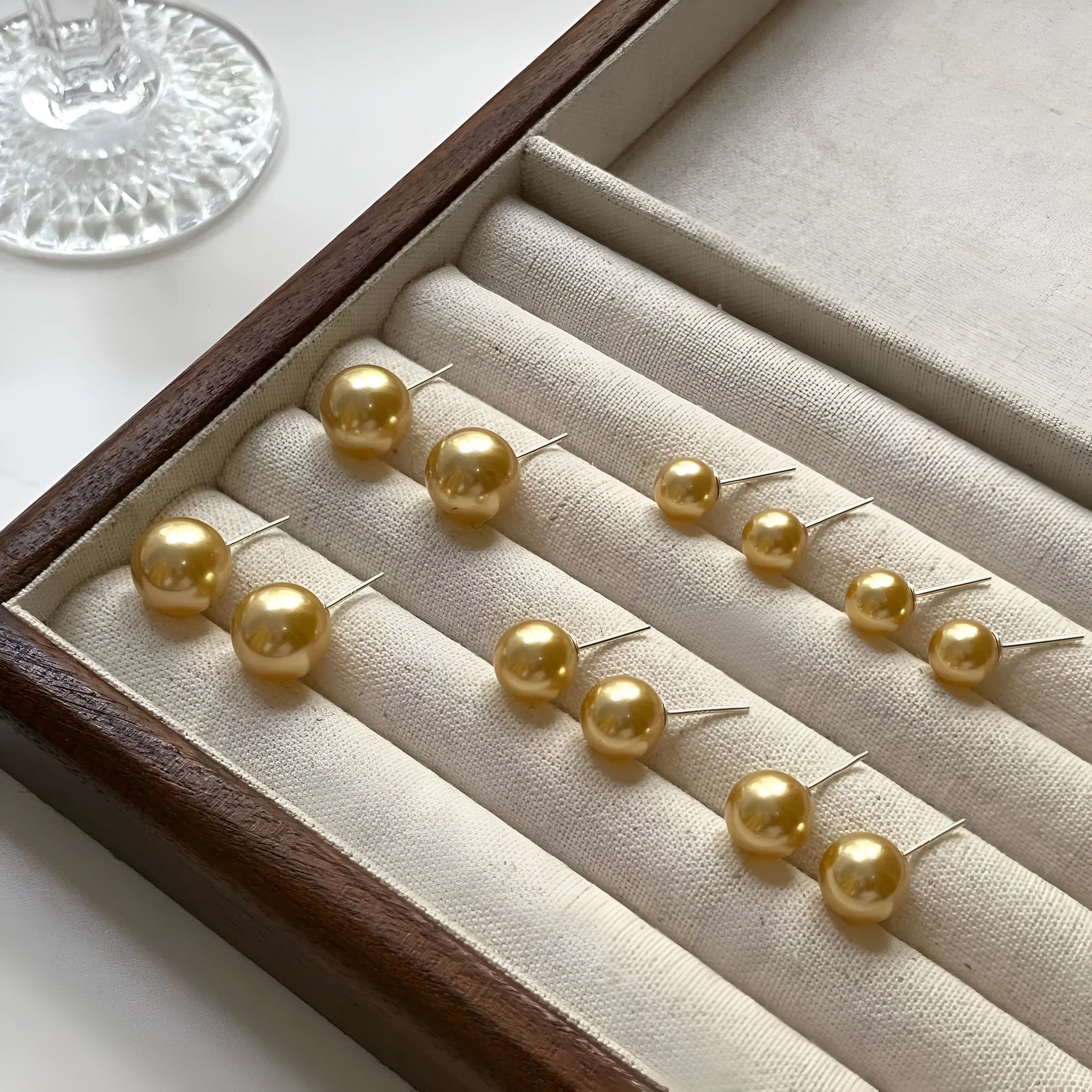 A pair of large geometric pearl stud earrings with an eight-point star accent on a silver setting.