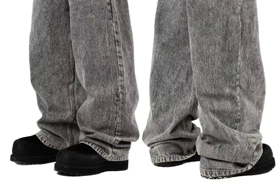 Grey loose fit straight leg denim trousers for men and women on a plain background