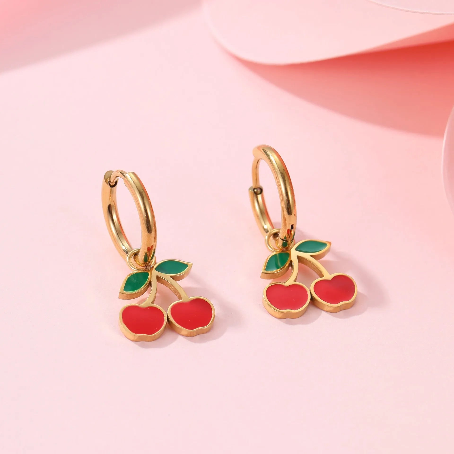 Four-piece cherry-themed jewellery set with gold electroplated necklace, bracelet, earrings, and ring on a white background.