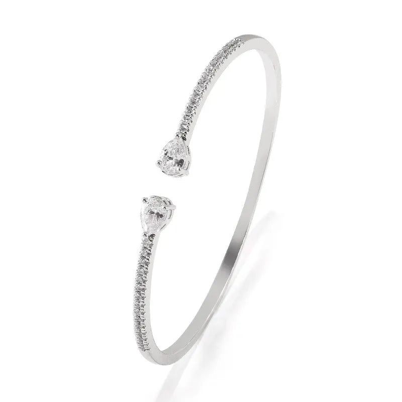 Copper bracelet with inlaid zircon stones in a simple style, shown in white and blue colour options.