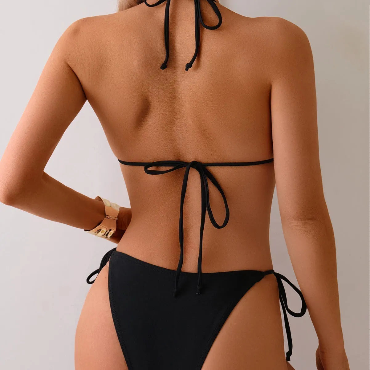 Black women's bikini swimsuit with metal bead detail on polyester fabric