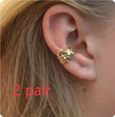 Women's gold starfish and conch shell drop earrings on white background