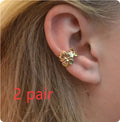 Women's gold starfish and conch shell drop earrings on white background