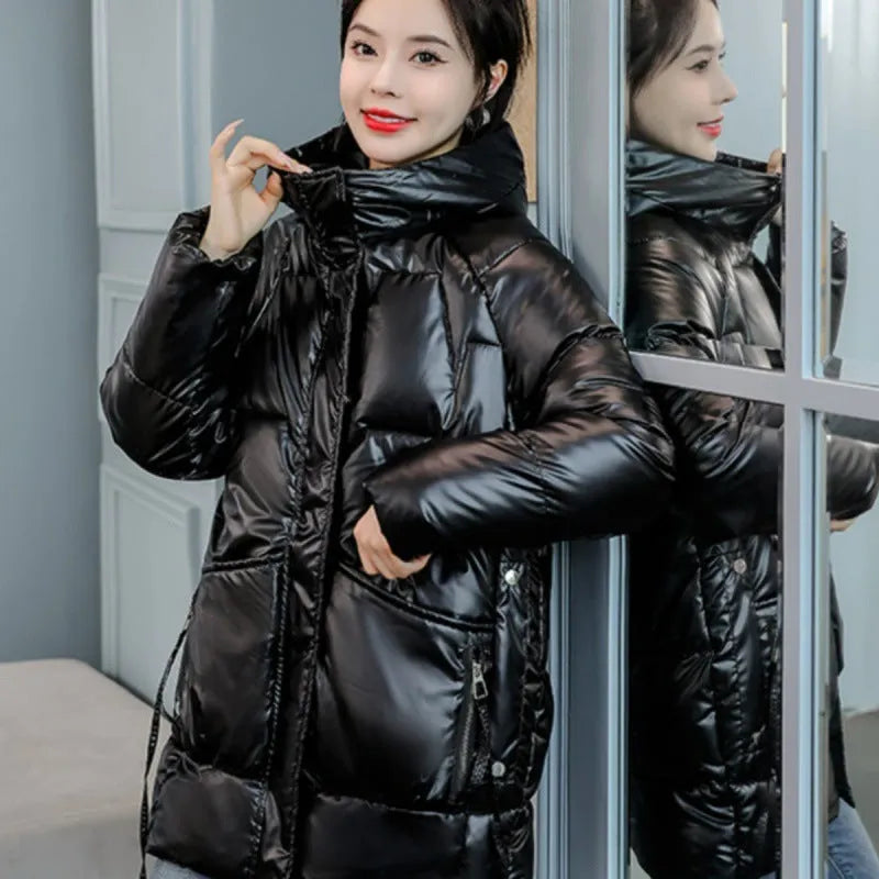 A woman wearing a loose-fit black hooded winter jacket, showcasing its long sleeves and thick construction.