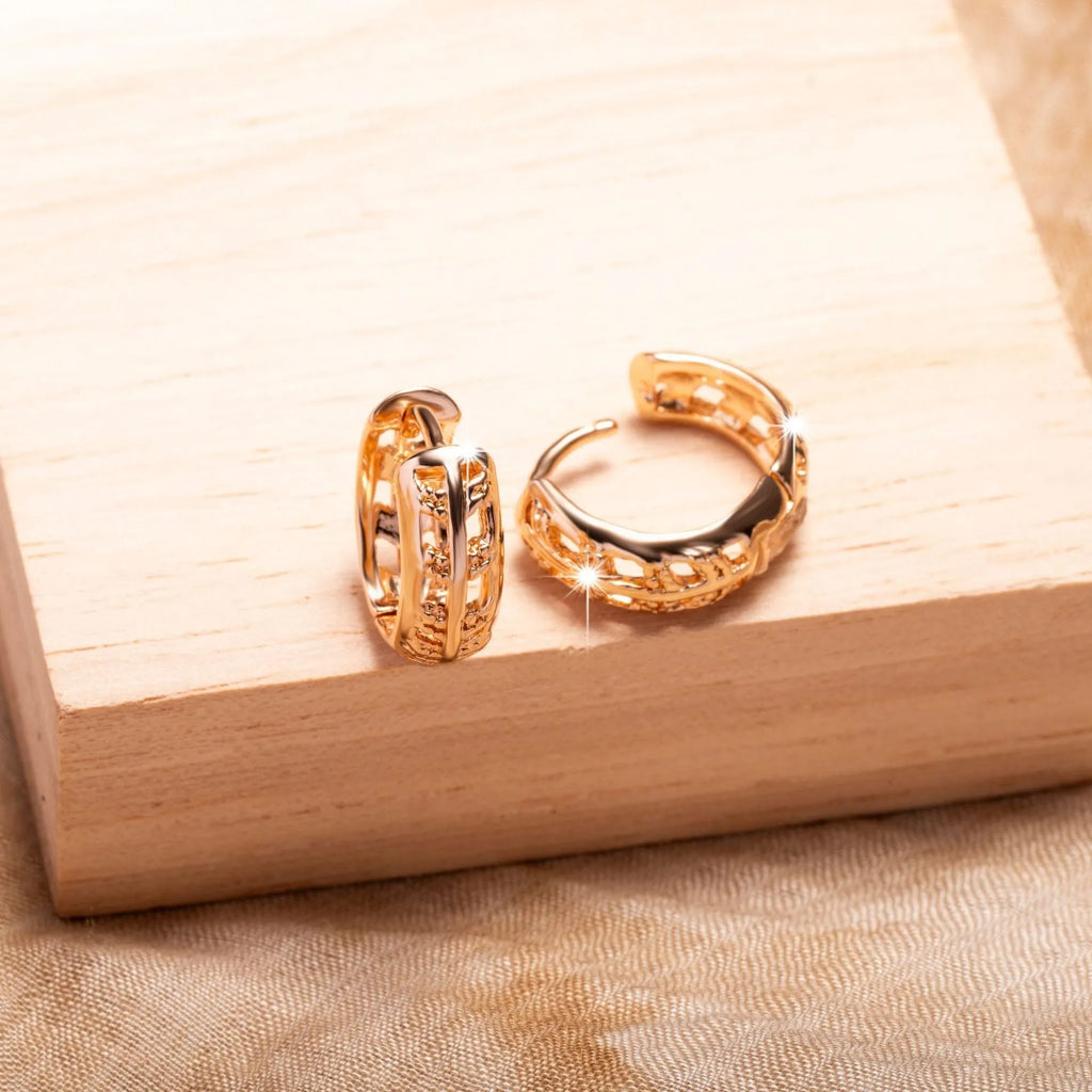 Rose gold hollowed out earrings with heart and leaf shapes on copper background