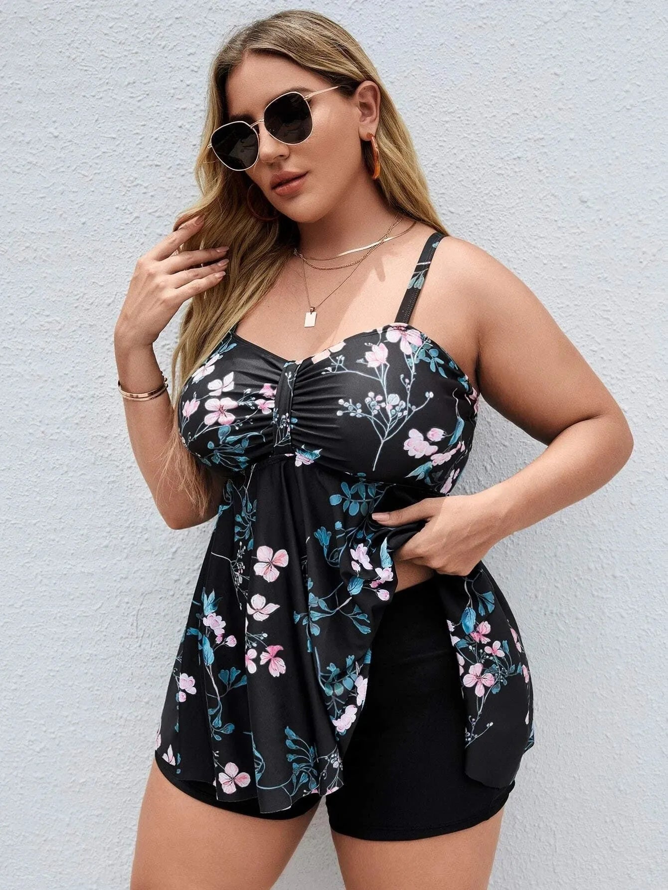 Women's floral print one-piece swimsuit on hanger, showing split colour design.
