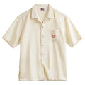 Light apricot men's shirt with bamboo print and a Cuban collar laid flat.