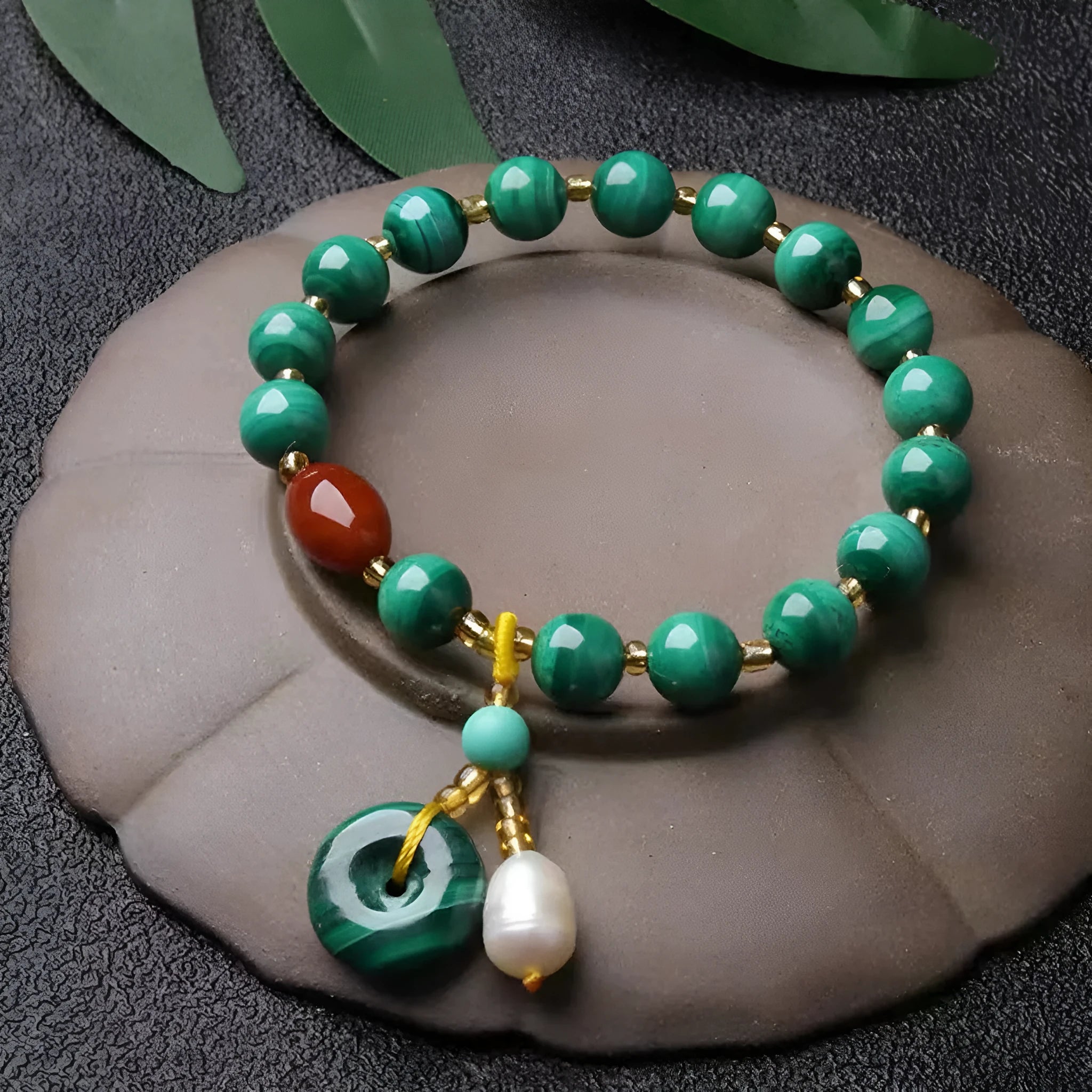 Natural malachite bracelet with green banded barrel beads on a neutral background
