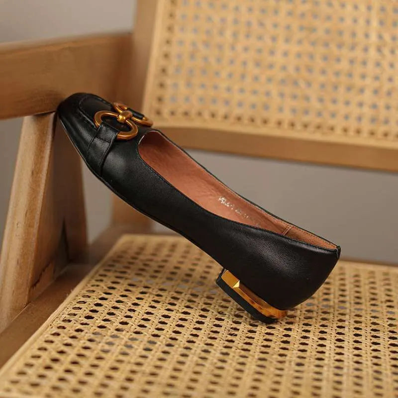 Women's black square toe Mary Jane pumps with metal detail and a low heel on a rubber sole.
