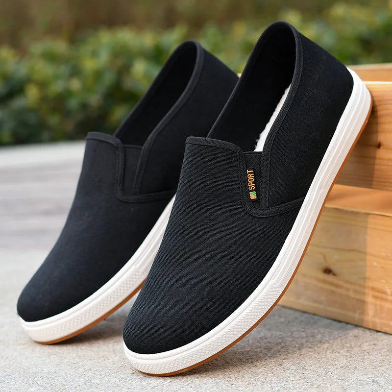 Men's low-top black and blue canvas slip-on shoes with round toe and shallow cut.