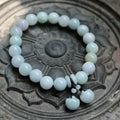 Natural emerald green jade hanging bracelet with Maitreya Buddha design on a geometric shape.