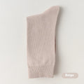Pack of men's solid colour mid-calf business socks in combed cotton on a neutral background.