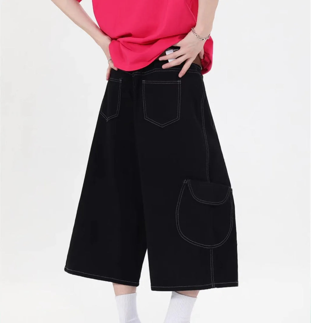 Women's retro denim shorts with multiple pockets in a wide-leg cropped style on a hanger.