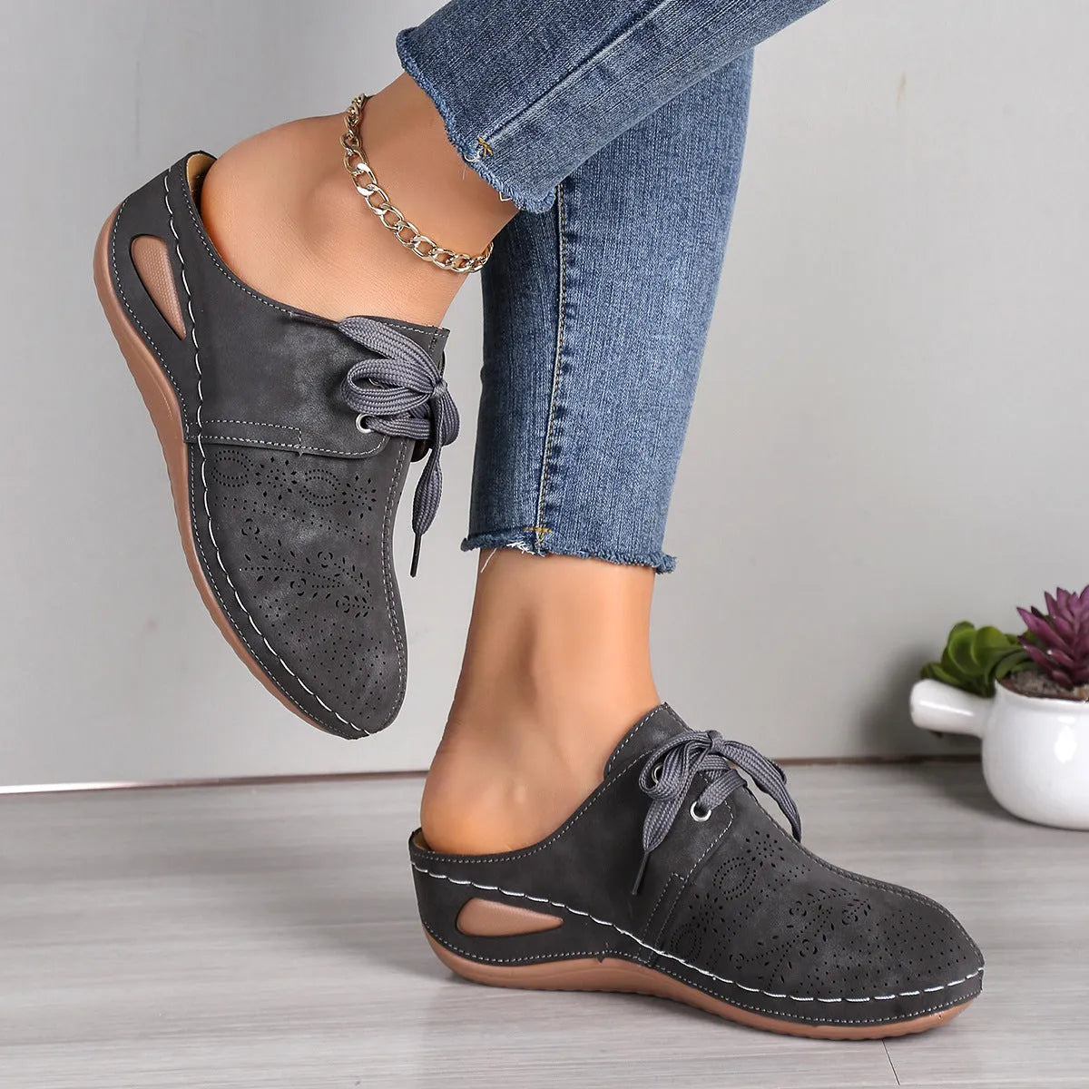 Women's black suede lace-up wedge slippers with a hollow out design and rubber sole.
