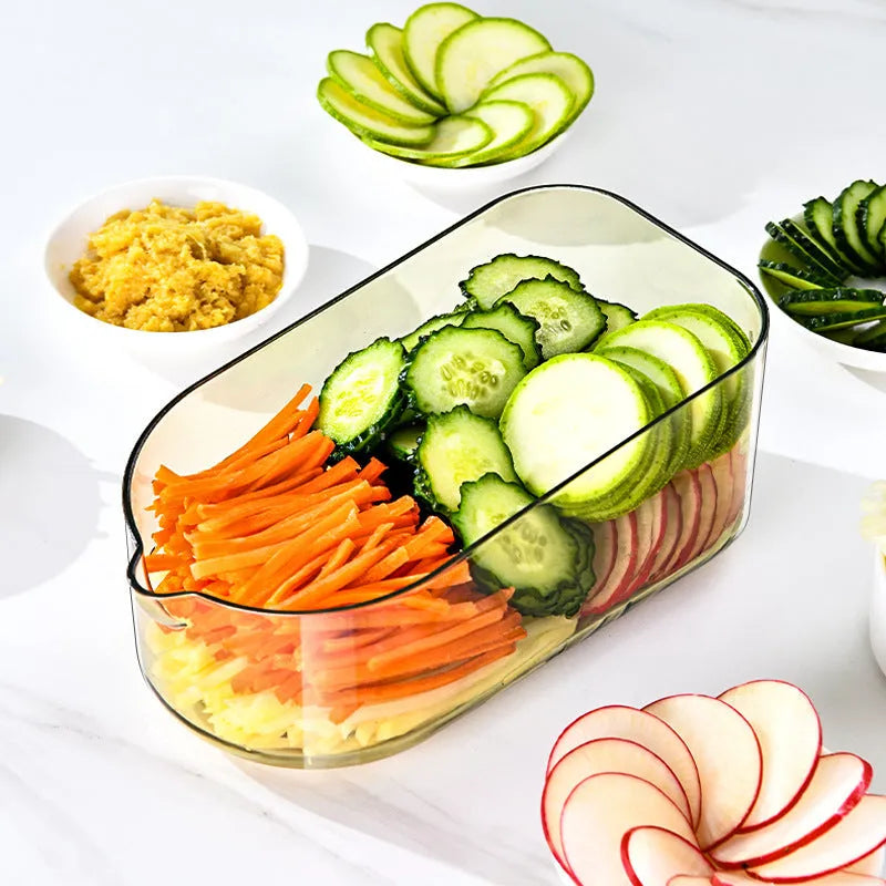 Transparent green vegetable chopper with multiple stainless steel blades and a hand protector on a kitchen worktop