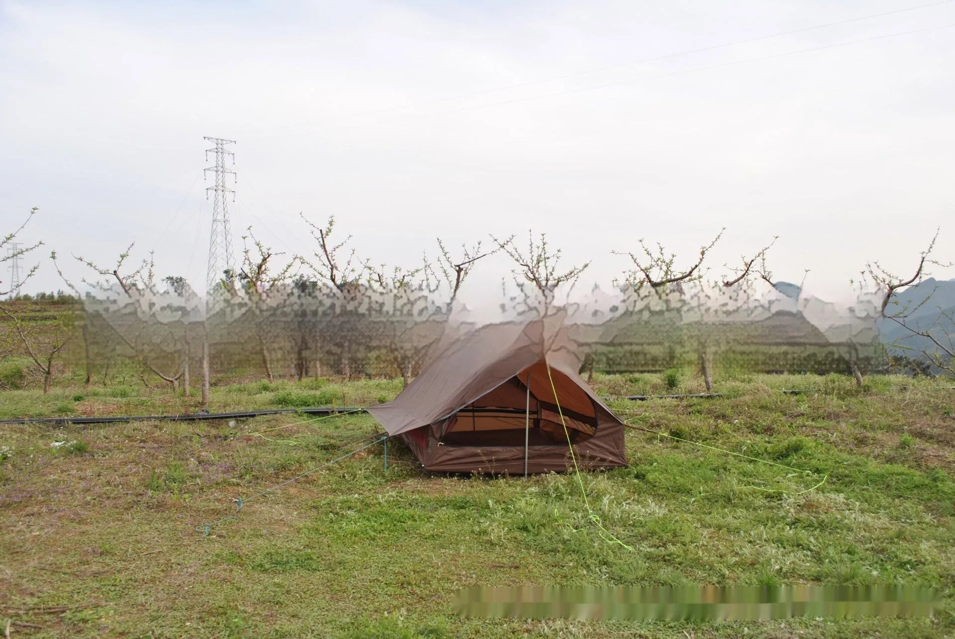 Brown A-frame hiking tent supported by hiking poles showing spacious interior for 2-3 campers