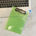 Transparent A4 writing board with metal clip holding papers, available in multiple colours