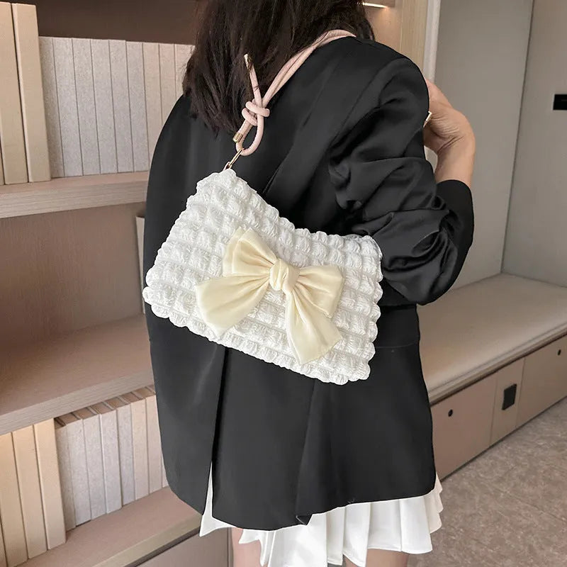 Women's horizontal square canvas handbag with single shoulder strap in black colour showing sandwich pocket detail