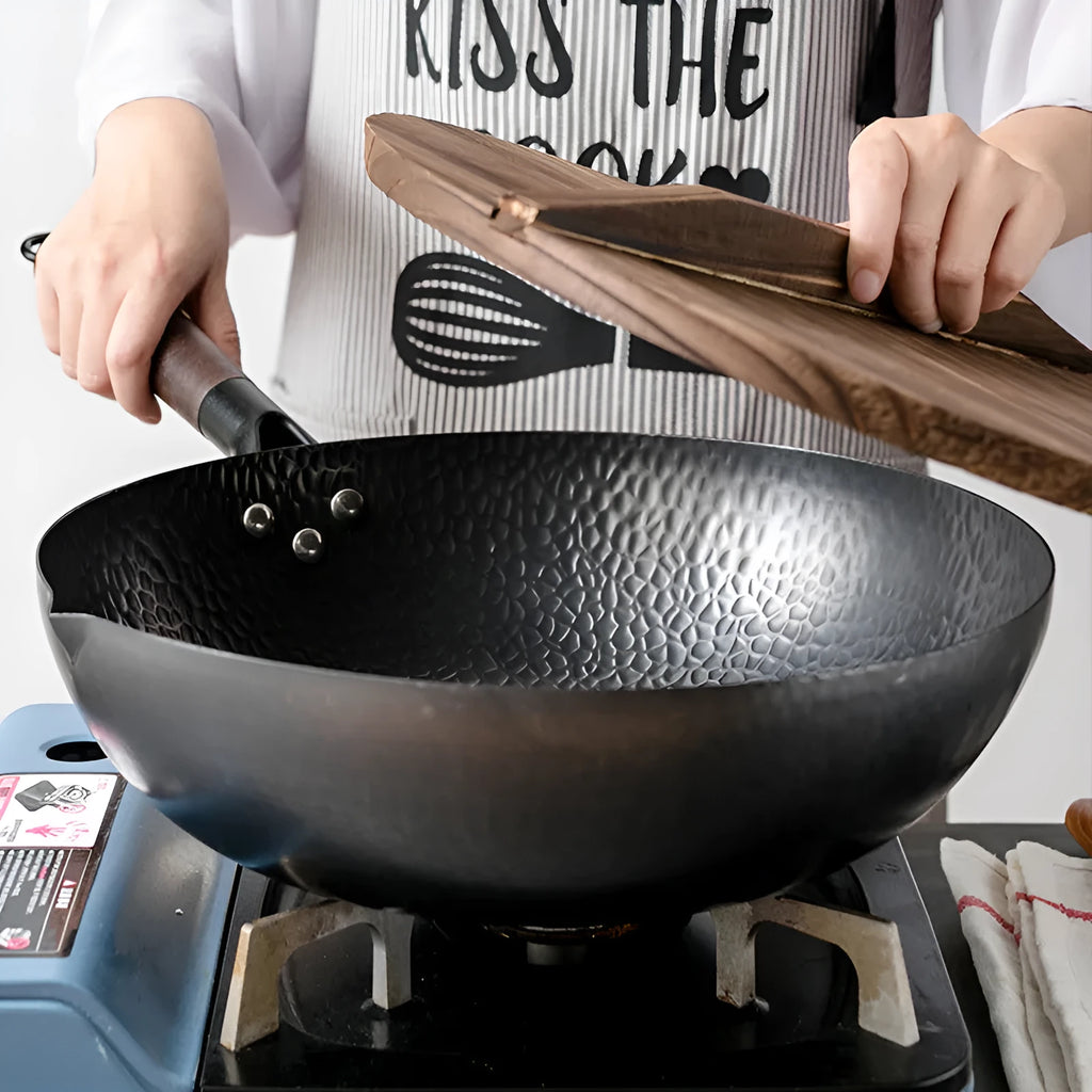 Traditional handmade iron wok pan with wooden handle and black finish