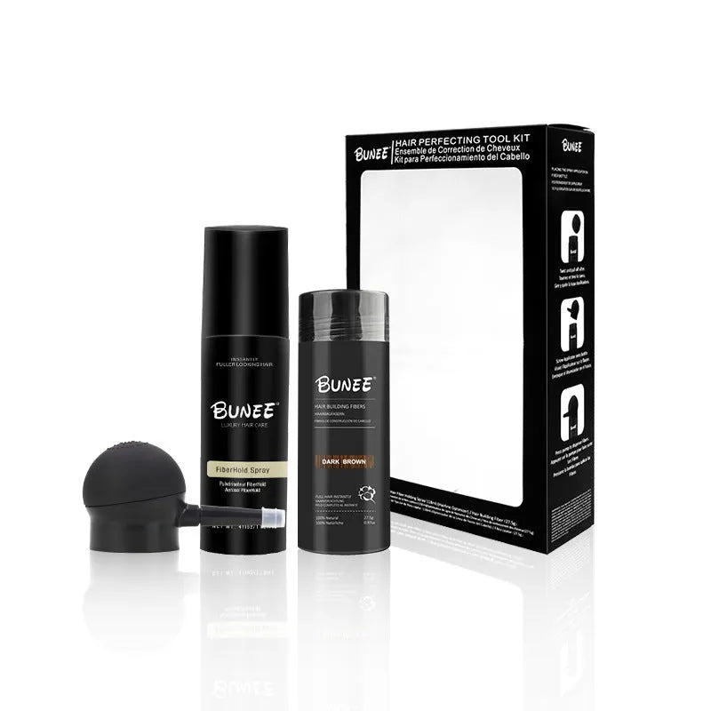 Hair fibre powder kit containing a 275g can, styling spray bottle, and applicator nozzle on a white background.