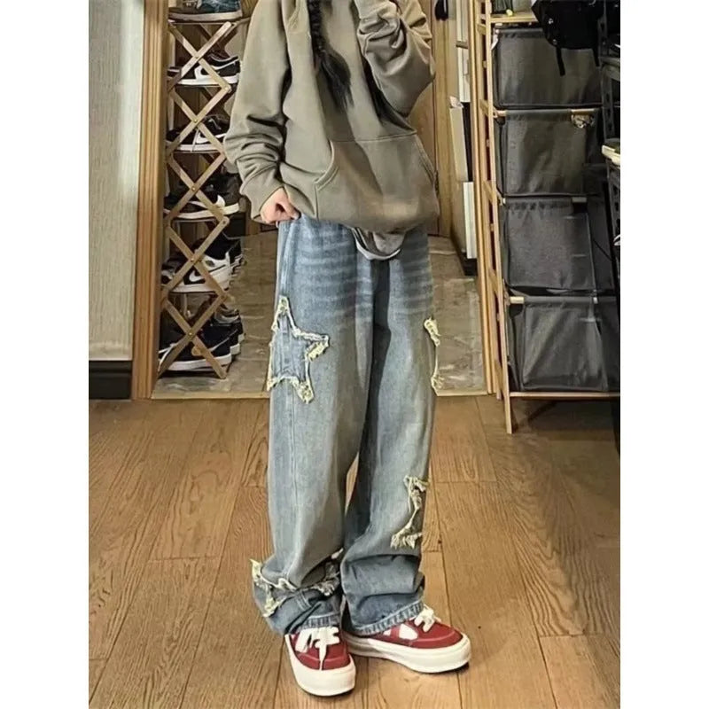 Blue high-waisted wide-leg denim trousers on a hanger, showing the straight-leg silhouette.
