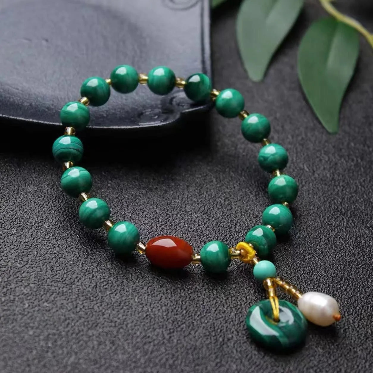 Natural malachite bracelet with green banded barrel beads on a neutral background