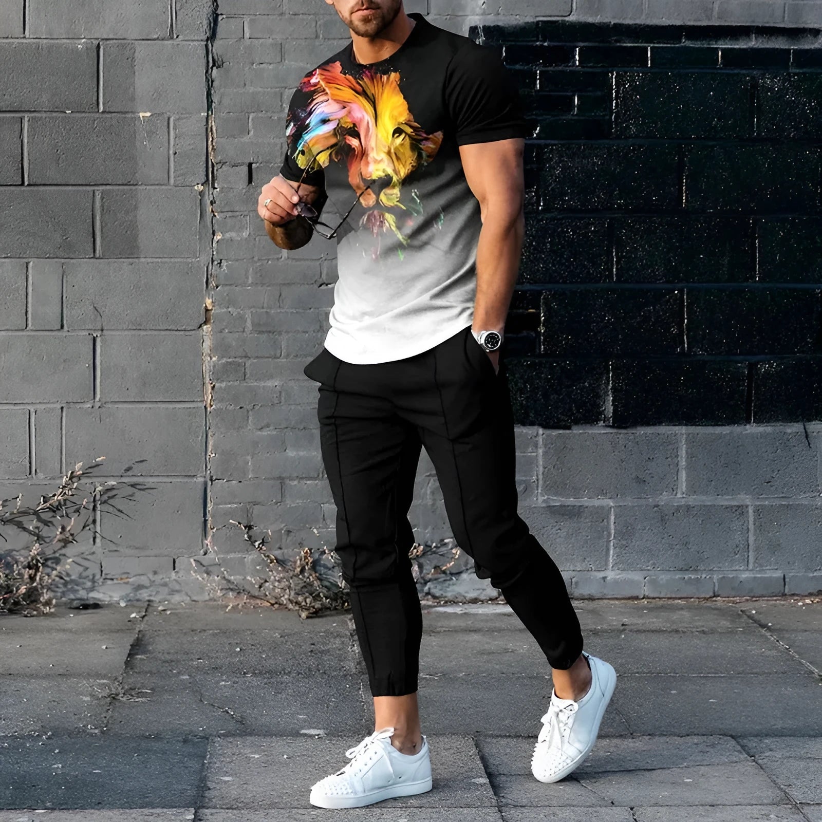 Man wearing a light grey short-sleeved pullover and matching trousers from a men's two-piece tracksuit set.