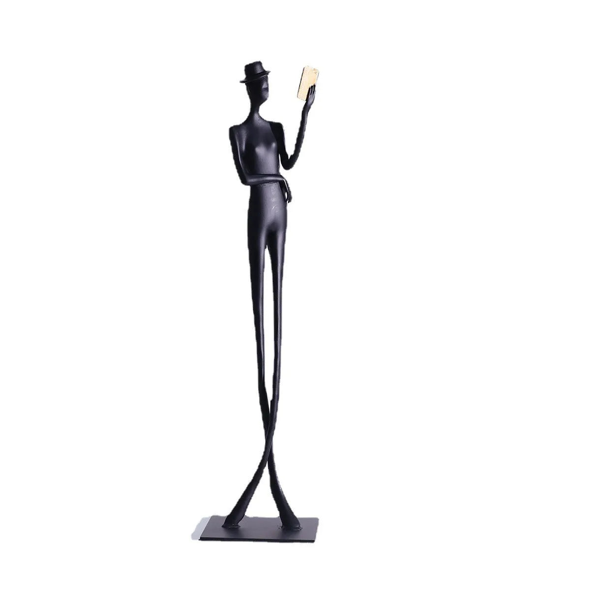 Black cast aluminium sculpture of a woman reading, 51cm tall on a desk.