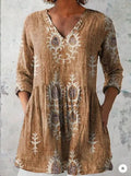 A woman wearing a vibrant printed loose-fitting dress with a wide waist and 3/4 length sleeves.