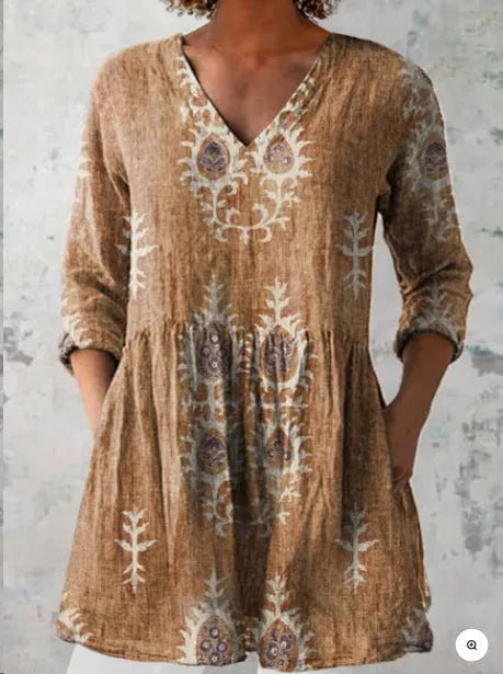A woman wearing a vibrant printed loose-fitting dress with a wide waist and 3/4 length sleeves.