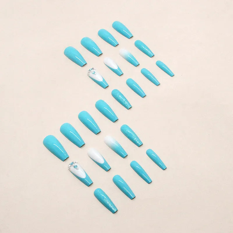 Long ballet-shaped false nails with solid blue colour and smart diamond glitter, shown with glue.