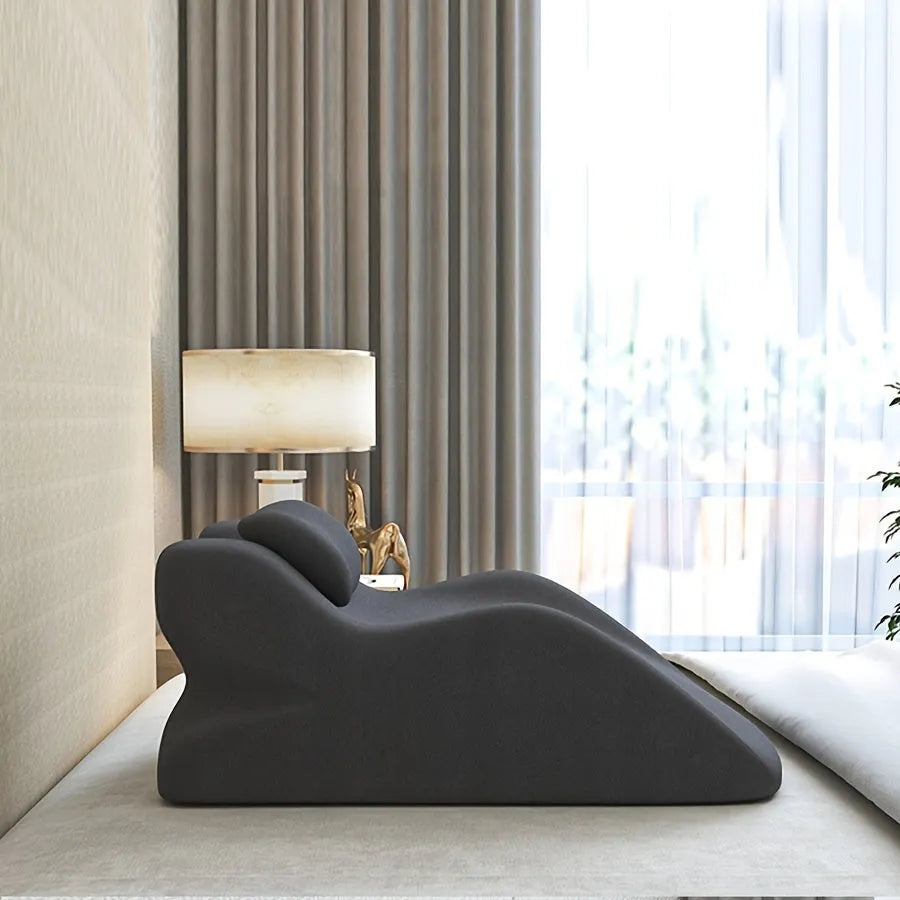 A stomach sleeper pillow in blue, designed for prone positioning and reading in bed.