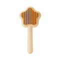 Green cat comb with stainless steel needles and self-cleaning magic wand function on white background