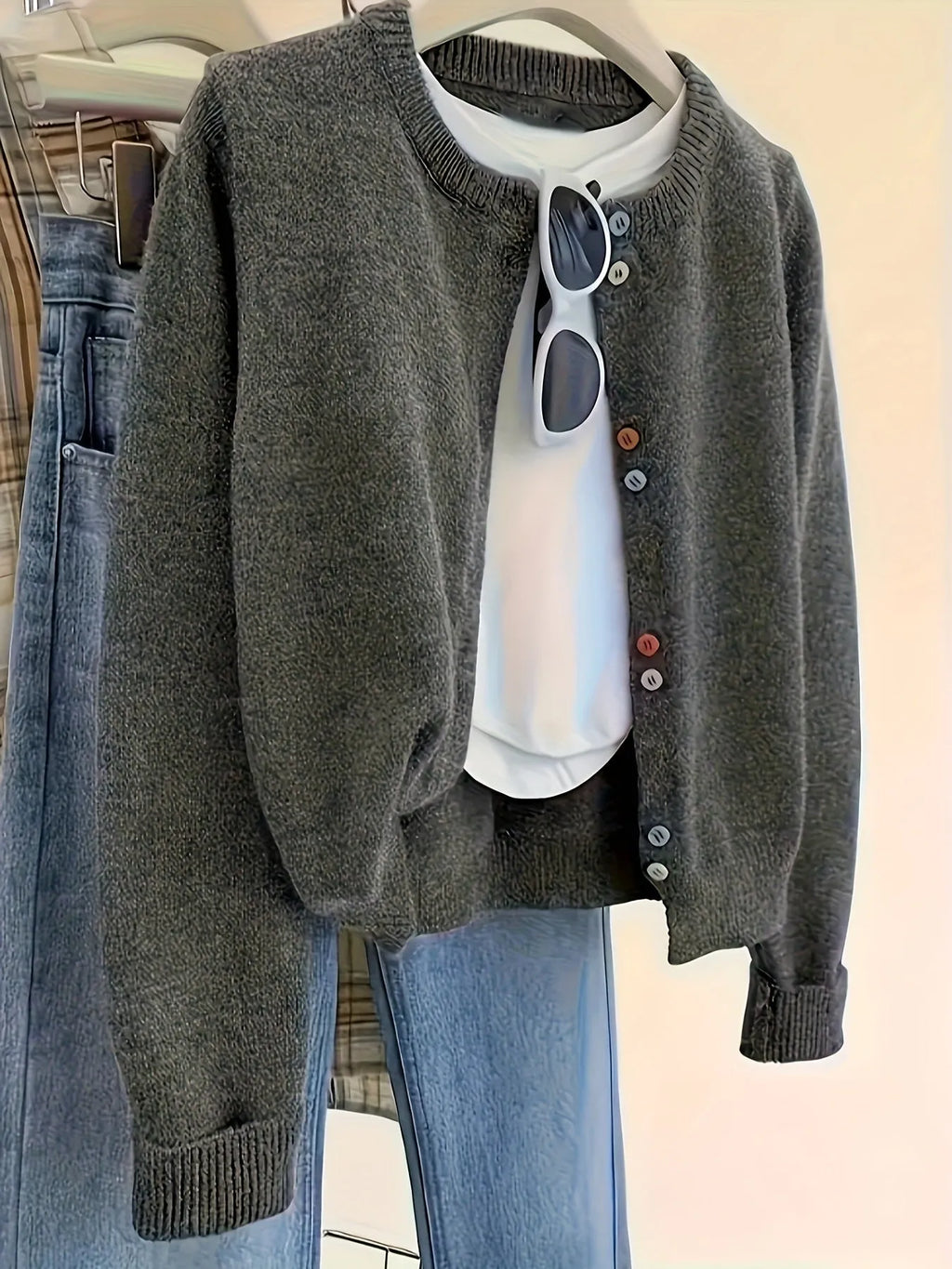 Dark grey women's button-front polyester cardigan on a hanger.