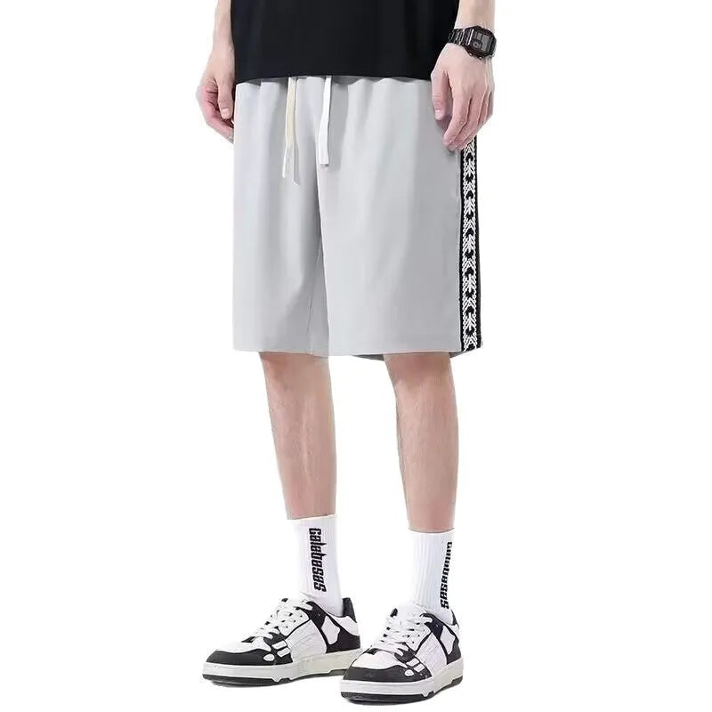 Men's black loose fit track trousers showing baggy sports design with elastic waist