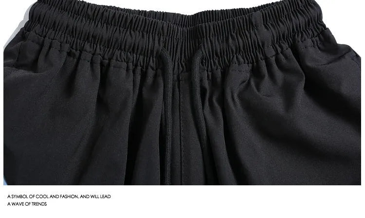 Men's black and grey quick-drying sports shorts with elastic waist and contrast colour panels for training