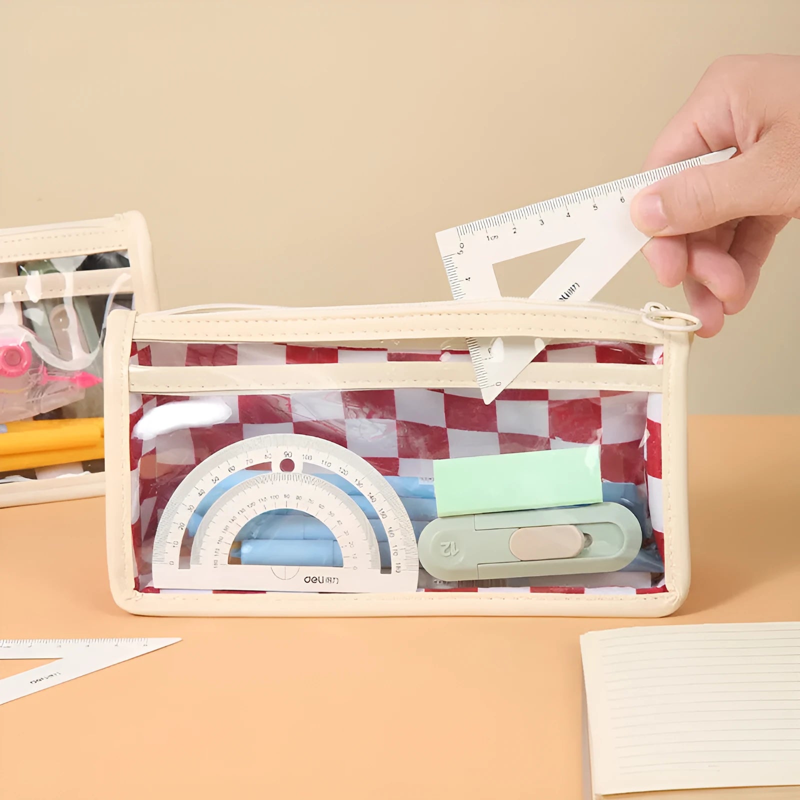 Transparent PVC pencil case with chessboard grid pattern showing pens inside, 21.5cm long