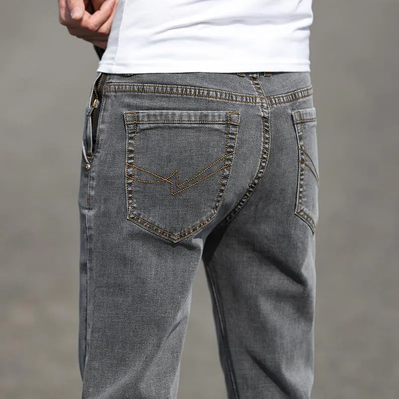 Men's smoky grey low waist straight leg jeans with a zipper fly, shown on a hanger.
