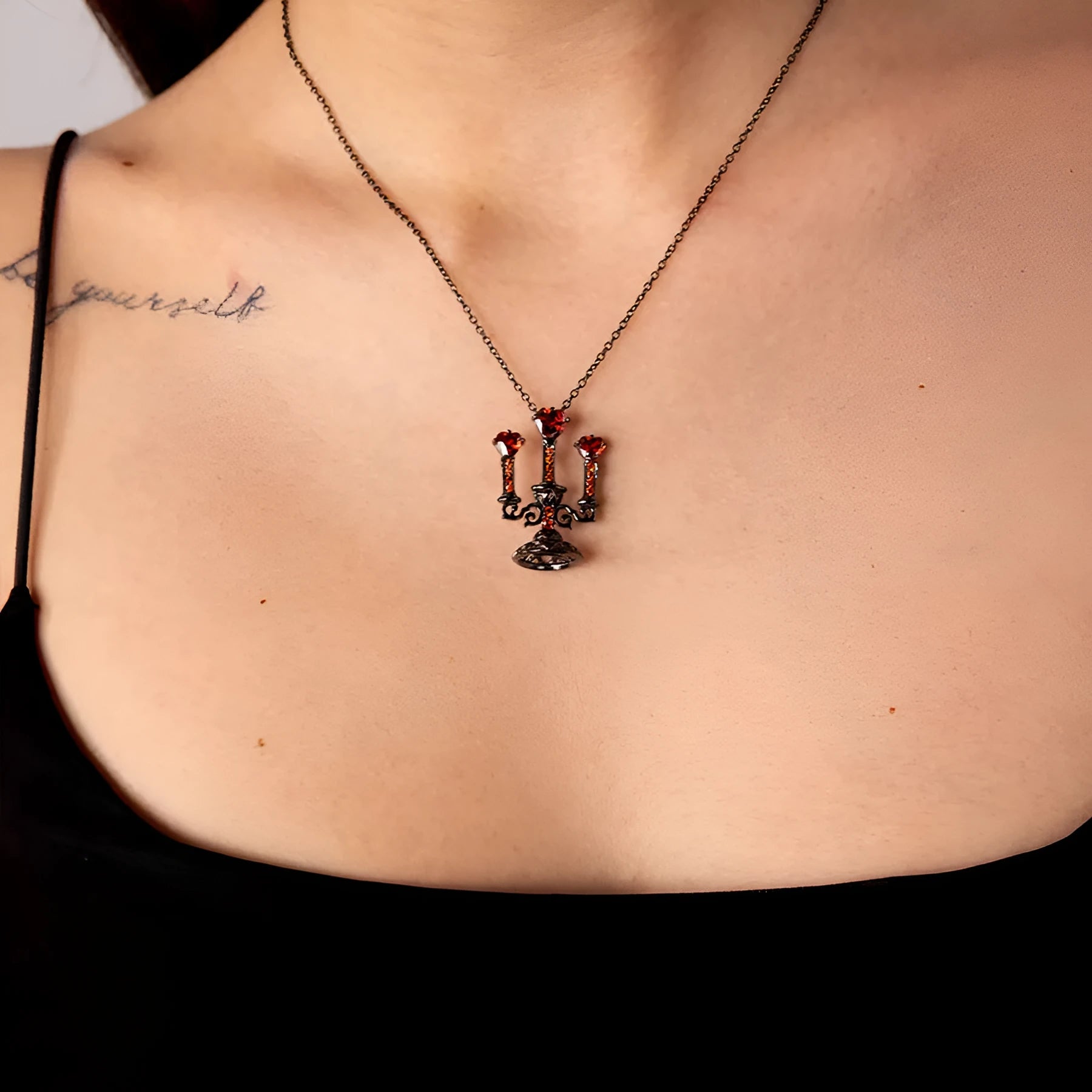 Close-up of a women's zinc alloy Gothic necklace with a hollow retro candlestick pendant on a cross chain.