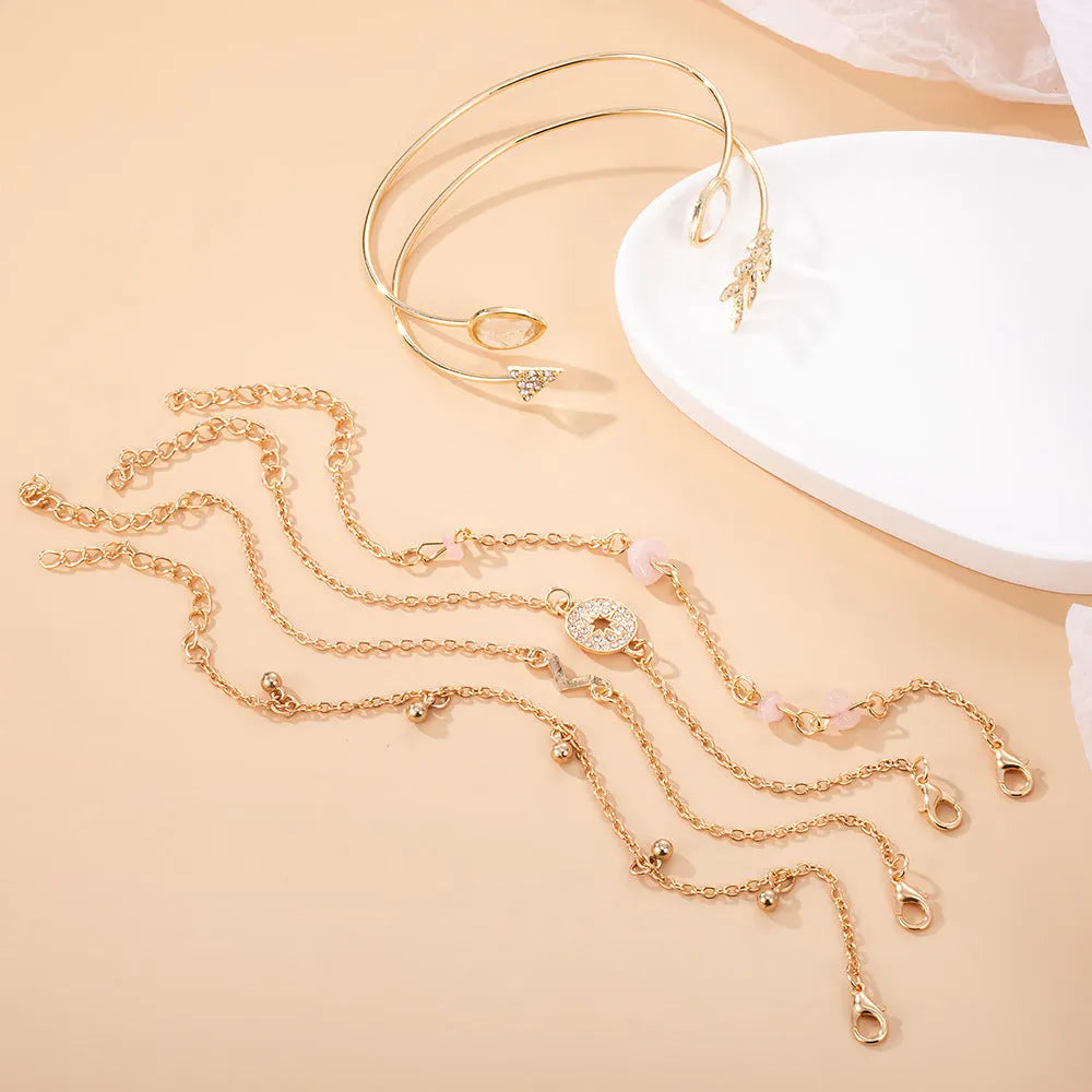 Six gold zinc alloy bracelets with V-shaped, water droplet, arrow and spot drill designs